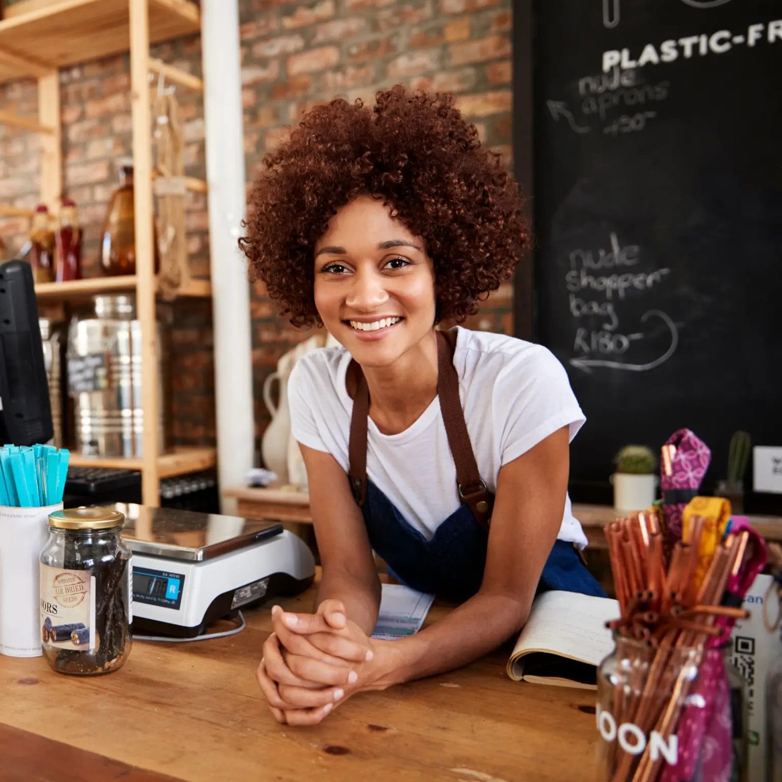 Portrait Of Female Owner Grocery Store Behind Sales Desk